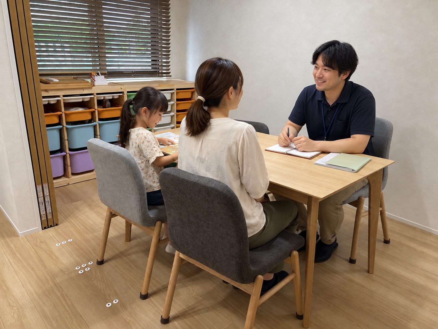 相談用テーブルを斜めから捉えた、保護者と指導員の相談イメージ（AI生成）